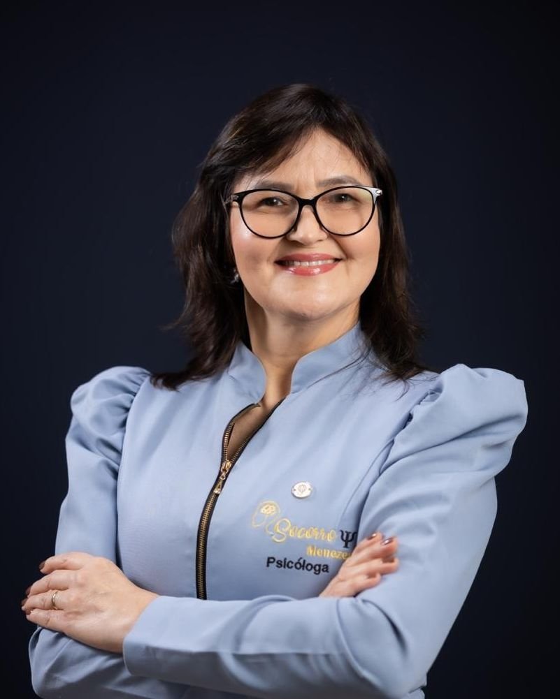 Maria Socorro de Menezes, psicóloga, de jaleco azul-claro, braços cruzados, sorrindo